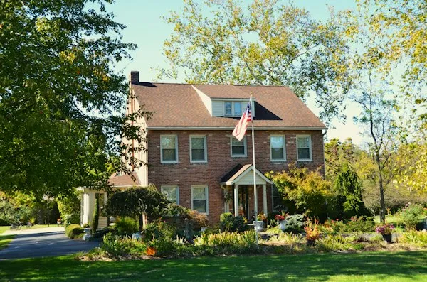 Brick house with a front lawn and flag